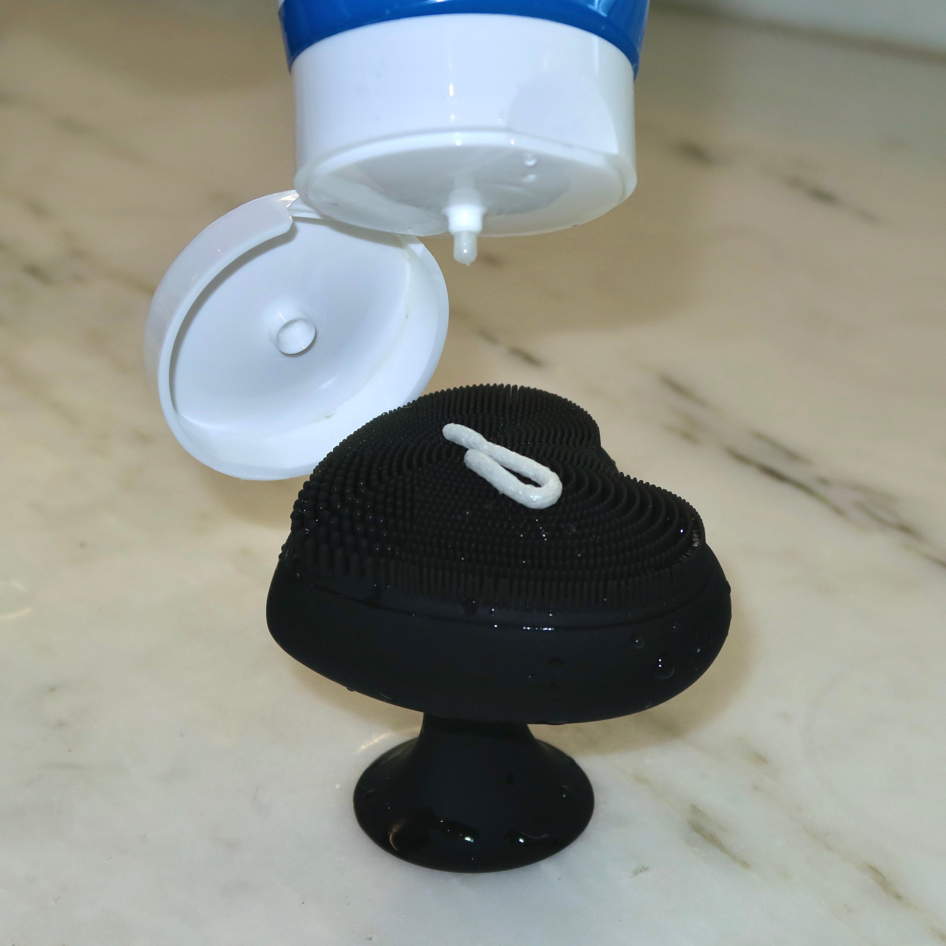 Black scrubber with a white cap being filled with blue liquid on a marble surface